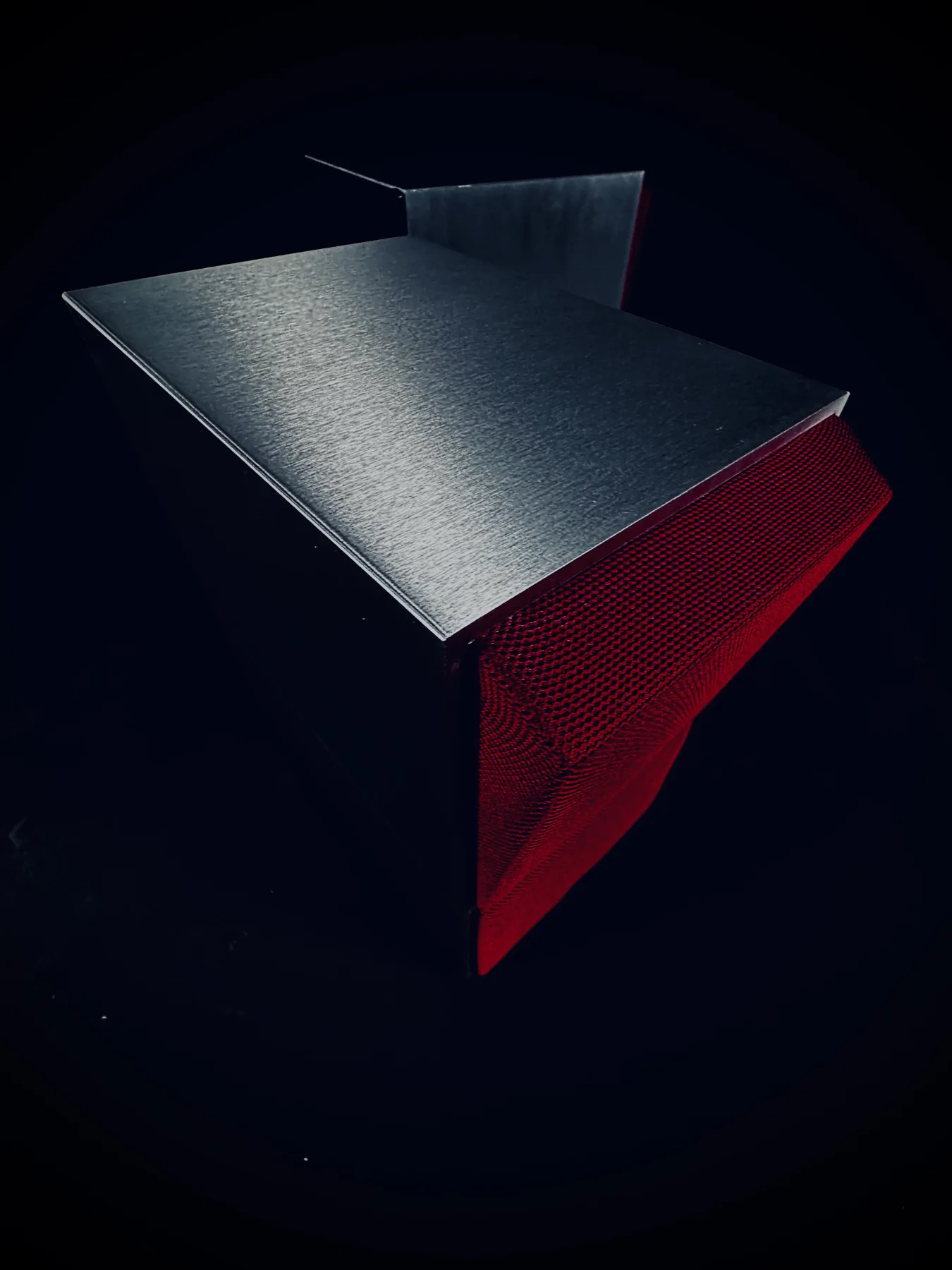 Detail der gebürsteten Aluminiumoberfläche und roten Stofffront